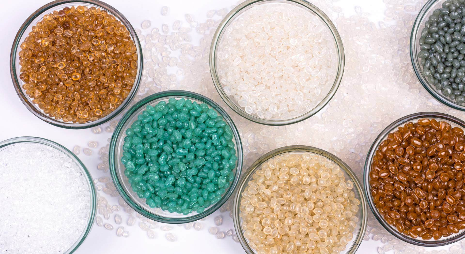 A vibrant assortment of PS recycled plastic pellets in various colors.